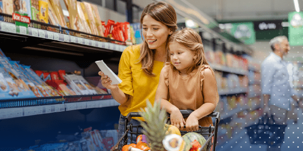 Grocery store shopper with cart looking at list